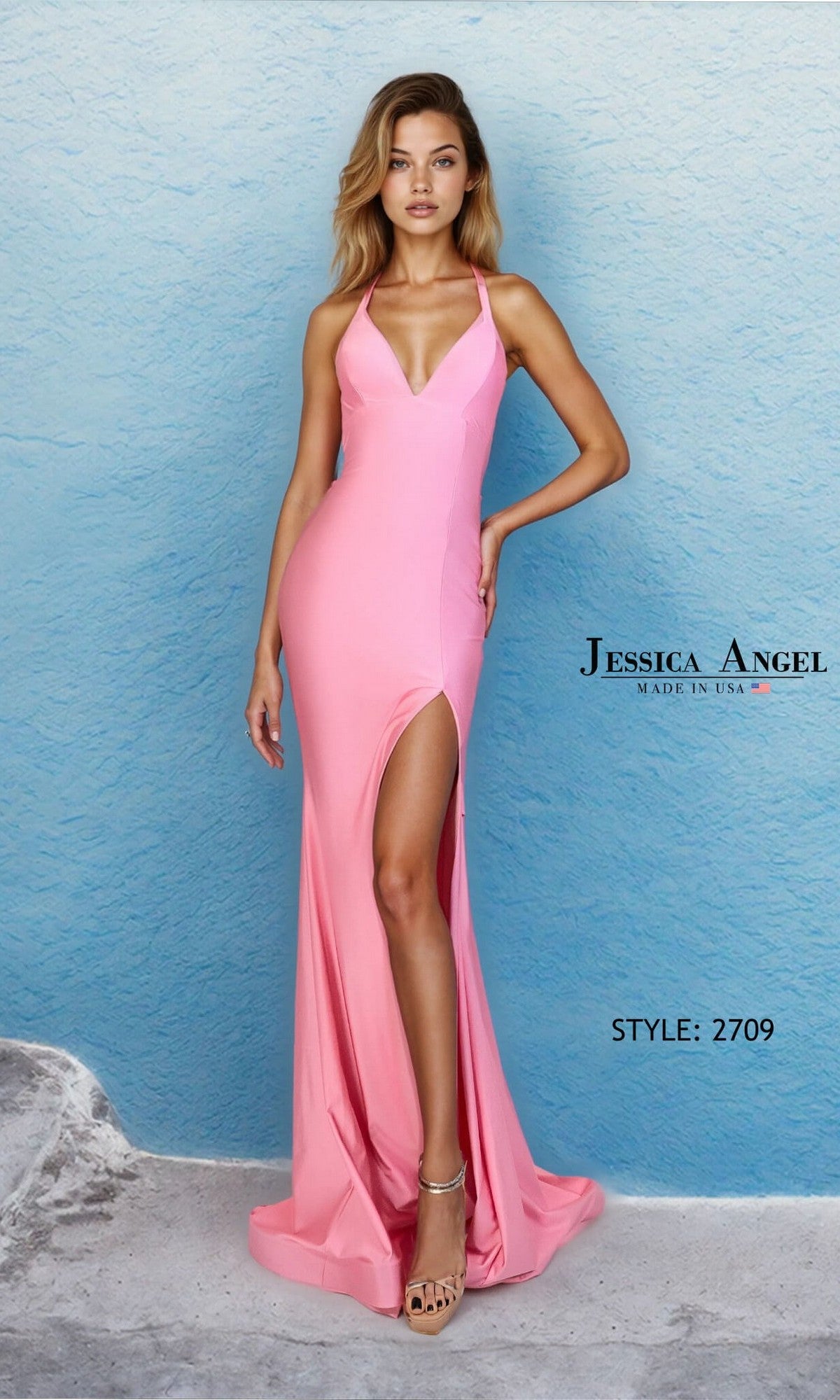 Woman wearing the Long Prom Dress: Jessica Angel 2709 in Berry Blush, featuring a sleeveless design, fitted sheath silhouette, and thigh-high slit, posing against a light blue textured wall. Made in USA.